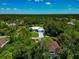 Beautiful aerial view of a single-Gathering home nestled within a lush green landscape with mature trees surrounding the property at 6964 Glacier Ave, North Port, FL 34291