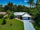 Aerial view of the home featuring a manicured lawn, a modern roof, and a spacious two-car garage at 6964 Glacier Ave, North Port, FL 34291