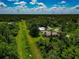 Wide aerial view displays the neighborhood, surrounded by dense tree coverage at 6964 Glacier Ave, North Port, FL 34291