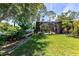 Expansive grassy backyard featuring a charming wooden pathway, a screened-in pool, and mature trees at 6964 Glacier Ave, North Port, FL 34291