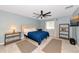 A nicely decorated bedroom features a ceiling fan, coastal wall decor, and wood look flooring at 6964 Glacier Ave, North Port, FL 34291