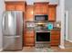 Modern kitchen with stainless steel appliances, granite countertops, and wood-look tile flooring at 6964 Glacier Ave, North Port, FL 34291
