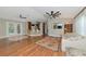 Bright and airy living room featuring hardwood floors, a large ceiling fan, and comfortable seating arrangement with an accent rug at 6964 Glacier Ave, North Port, FL 34291