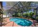 A bright and refreshing screened-in pool area surrounded by lush greenery and natural light at 6964 Glacier Ave, North Port, FL 34291