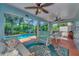 Screened-in porch with comfortable seating overlooking the beautiful blue in-ground pool at 6964 Glacier Ave, North Port, FL 34291