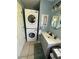 Bathroom with stackable washer and dryer unit and modern vanity with a round mirror at 700 Forest St, Nokomis, FL 34275