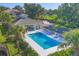 Aerial view of a community pool with people swimming, surrounded by palm trees and lush landscaping at 700 Gardens Edge Dr # 722, Venice, FL 34285