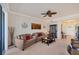 Comfortable living room with neutral tones, ceiling fan, and sliding door to a patio at 700 Gardens Edge Dr # 722, Venice, FL 34285