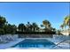 Community pool with palm trees and blue sky in the background at 700 Gardens Edge Dr # 722, Venice, FL 34285