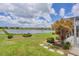 Backyard features a tranquil lake view, lush lawn, and well-manicured landscaping at 809 Derbyshire Dr, Venice, FL 34285