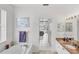 Bright bathroom featuring a tub with jets, granite counters, and access to the bedroom at 809 Derbyshire Dr, Venice, FL 34285
