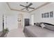 Bright bedroom with a ceiling fan and tiled floors leading to the en-suite bathroom at 809 Derbyshire Dr, Venice, FL 34285
