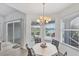 Cozy breakfast nook with a chandelier, offering picturesque views of the lake and access to an outdoor patio at 809 Derbyshire Dr, Venice, FL 34285