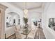 Bright dining room features a chandelier, glass table, and elegant rug, perfect for entertaining guests at 809 Derbyshire Dr, Venice, FL 34285