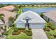 Charming single-story home features well-manicured landscaping and a paver driveway, nestled by a serene lake at 809 Derbyshire Dr, Venice, FL 34285