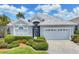 Inviting home with manicured landscaping and a paver driveway, featuring a secure front gate and attached two-car garage at 809 Derbyshire Dr, Venice, FL 34285