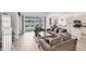 Spacious living room with neutral tones, wood flooring, and sliding glass doors opening to a scenic lake view at 809 Derbyshire Dr, Venice, FL 34285