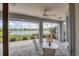 Covered patio with fan and seating area offers beautiful views of the lake at 809 Derbyshire Dr, Venice, FL 34285