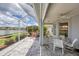 Enclosed patio boasts scenic lake views, outdoor seating and well manicured landscape at 809 Derbyshire Dr, Venice, FL 34285