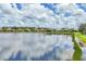 Scenic water view of homes reflecting clear skies on the lake at The Plantation community, Venice, Florida at 809 Derbyshire Dr, Venice, FL 34285