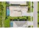 Aerial shot showcasing the home's layout, including a pool and driveway, in a well-manicured neighborhood at 8245 Grande Shores Dr, Sarasota, FL 34240