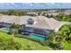 Aerial view of the property with a screened-in pool, surrounded by lush greenery in a residential area at 8245 Grande Shores Dr, Sarasota, FL 34240