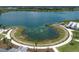 Aerial view of a community lake with a scenic walking path and lush greenery at 8245 Grande Shores Dr, Sarasota, FL 34240