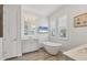 Bathroom features a soaking tub, dual vanities, and plantation shutters for natural light at 8245 Grande Shores Dr, Sarasota, FL 34240