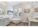 Bathroom with a soaking tub, dual vanities, decorative seashell art, and plantation shutters at 8245 Grande Shores Dr, Sarasota, FL 34240