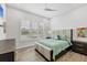 This bedroom features wood floors, a large window, and neutral decor at 8245 Grande Shores Dr, Sarasota, FL 34240