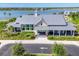Stunning view of the community clubhouse featuring modern architecture and lush landscaping near the water at 8245 Grande Shores Dr, Sarasota, FL 34240