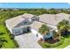 Charming home exterior featuring a well-manicured lawn, tile roof, and a three-car garage at 8245 Grande Shores Dr, Sarasota, FL 34240