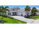 Beautiful home boasts a three-car garage, paver driveway, and tropical landscaping at 8245 Grande Shores Dr, Sarasota, FL 34240