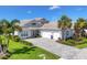 Attractive one-story home with a manicured lawn, paver driveway, and a convenient three-car garage at 8245 Grande Shores Dr, Sarasota, FL 34240
