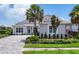 Charming home with a paver driveway, lush landscaping, and a welcoming front entrance at 8245 Grande Shores Dr, Sarasota, FL 34240