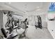 Home gym featuring varied exercise machines, a ceiling fan, and wall-mounted television at 8245 Grande Shores Dr, Sarasota, FL 34240