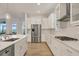 Modern kitchen showcasing stainless steel appliances, sleek white cabinets, and a spacious layout at 8245 Grande Shores Dr, Sarasota, FL 34240