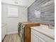 Well-lit laundry room with gray tiled accent wall and butcher block over the washer and dryer at 8245 Grande Shores Dr, Sarasota, FL 34240