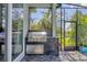 Built in outdoor kitchen with stainless steel grill, storage, and brick backsplash at 8245 Grande Shores Dr, Sarasota, FL 34240
