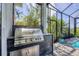 Outdoor kitchen with stainless steel grill and beautiful landscaping at 8245 Grande Shores Dr, Sarasota, FL 34240