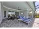 Covered patio with seating, dining, a grill, and sun loungers next to the pool at 8245 Grande Shores Dr, Sarasota, FL 34240