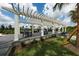 Relaxing pergola with shade, seating, and manicured landscaping at 8245 Grande Shores Dr, Sarasota, FL 34240