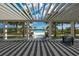 Relaxing pergola frames a pool view with palms and bright skies at 8245 Grande Shores Dr, Sarasota, FL 34240