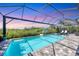 Screened-in pool and spa with seating and lush landscaping, offering a relaxing backyard retreat at 8245 Grande Shores Dr, Sarasota, FL 34240