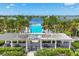 Beautiful community pool with palm trees and a lake view, perfect for relaxation and recreation at 8245 Grande Shores Dr, Sarasota, FL 34240