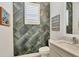Stylish powder room featuring accent wall with unique tile design, modern vanity, and decor at 8245 Grande Shores Dr, Sarasota, FL 34240