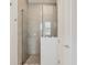 Modern glass-enclosed shower featuring neutral tile and updated fixtures at 8245 Grande Shores Dr, Sarasota, FL 34240