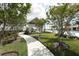 Scenic walking path leading to a gazebo and pool area, surrounded by beautifully manicured landscaping at 8245 Grande Shores Dr, Sarasota, FL 34240