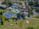 Aerial view of a community clubhouse with tennis and pickleball courts, community pool, parking and golf green at 841 Waterside Dr # 202, Venice, FL 34285