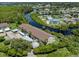Aerial view of a building by the water with parking and mature trees in a lush, green setting at 841 Waterside Dr # 202, Venice, FL 34285